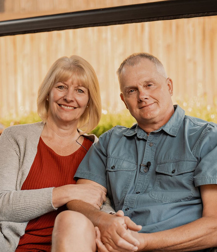 Couple relaxing on covered patio with retractable screen